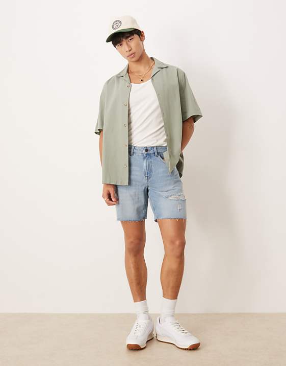 ASOS DESIGN mid length slim denim shorts with rips in light wash blue